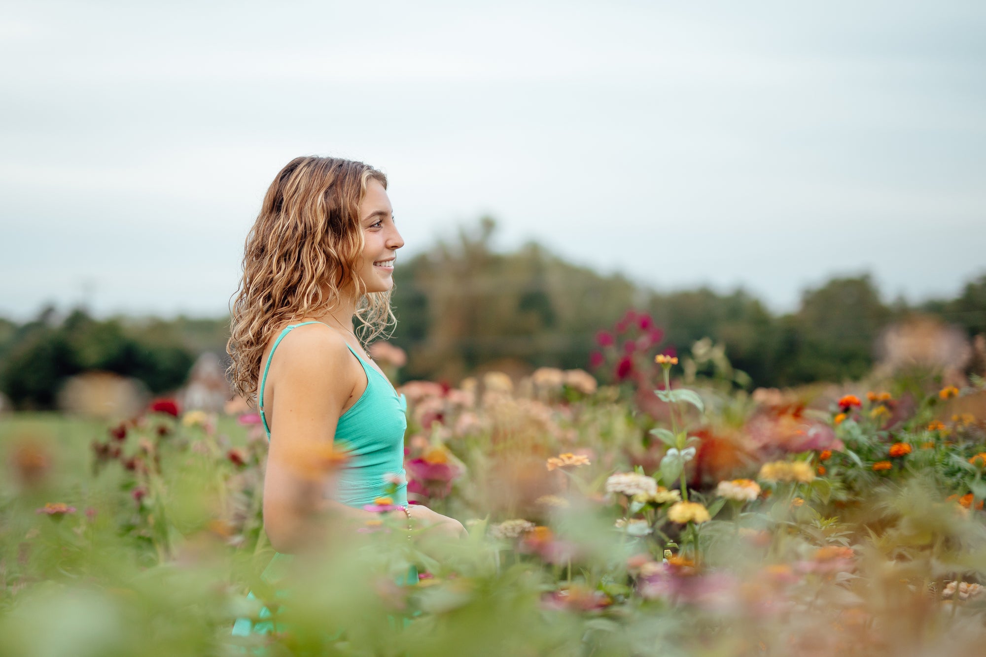 Woman standing in a field of flowers with a blurred background